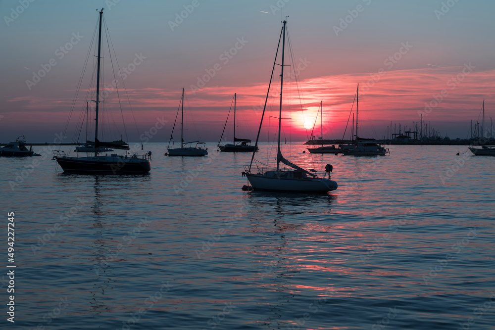Sunrise on the seashore. In the silhouette of the ships in the harbor. Selective focus Sunrise on the seashore. In the silhouette of the ships in the harbor. Selective focus