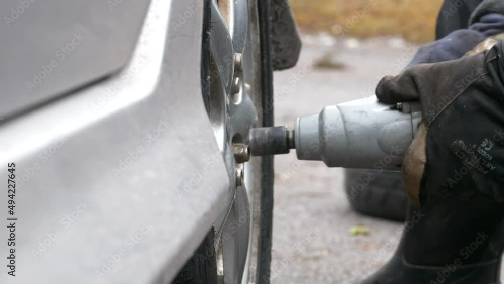 Close up of unrecognizable person hands changing season Tire at home