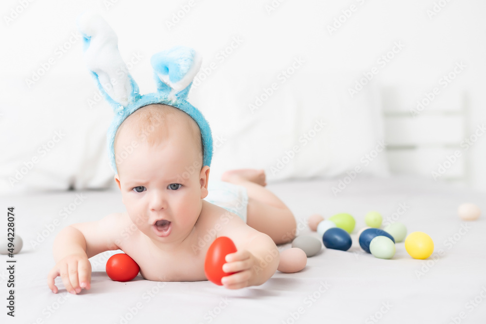 Portrait of a cute baby dressed in Easter bunny ears with a basket full of eggs Portrait of a cute baby dressed in Easter bunny ears with a basket full of eggs