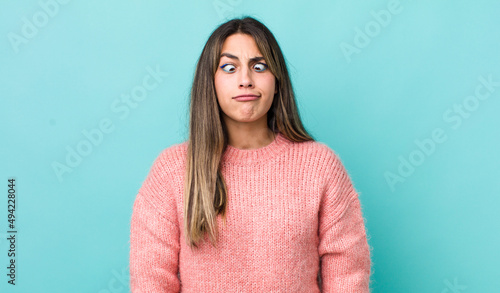 pretty hispanic woman looking goofy and funny with a silly cross-eyed expression, joking and fooling around