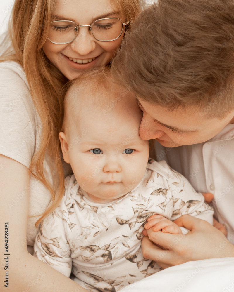 Portrait of cheerful smiling cozy and married couple. Woman in glasses, man, baby. Protection and support kid in family Portrait of cheerful smiling cozy and married couple. Woman in glasses, man, baby. Protection and support kid in family