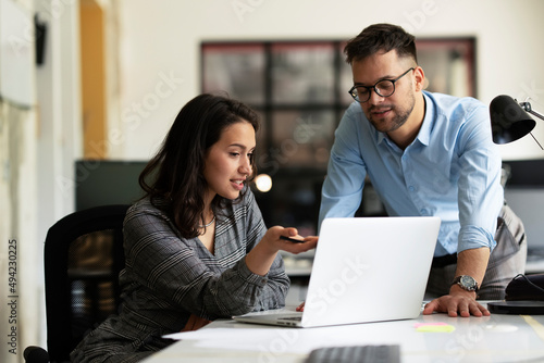 Colleagues in office. Businesswoman and businessman discussing work in office.