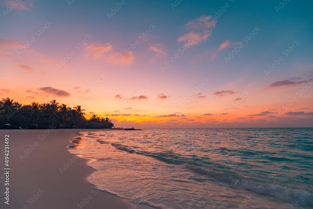 Obraz premium Sunset island beach. Paradise landscape beach. Tropical nature sea sand sky with palm tree forest silhouette and relaxing ocean water waves. Beautiful travel beach, sunrise over vacation destination