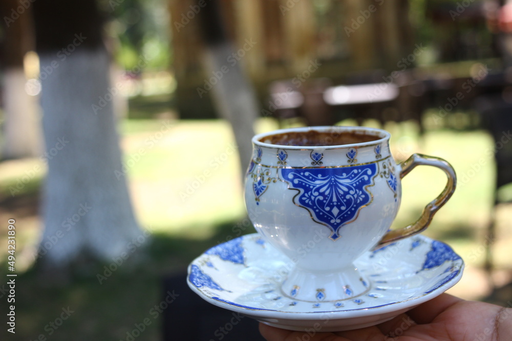 Hand holding cup of turkish coffee in nature Hand holding cup of turkish coffee in nature