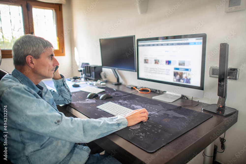 Man works from home in front of computer. Man works from home in front of computer.