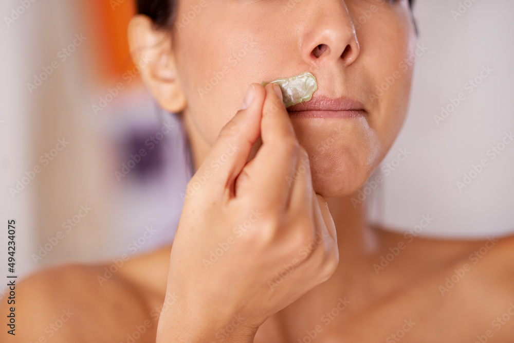 Kissable lips in the making. Shot of a woman waxing her upper lip. Kissable lips in the making. Shot of a woman waxing her upper lip.