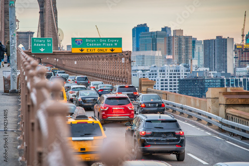 Cars speeding at sunset on Brooklyn Bridge at sunset, Manhattan. One of the most iconic bridges in the world, NY - USA.