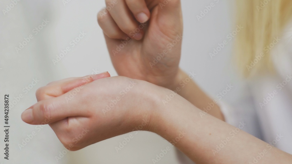 Fototapeta premium Close-up of an unrecognizable girl applying perfume on her wrist