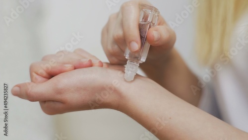 Close-up of an unrecognizable girl applying perfume on her wrist