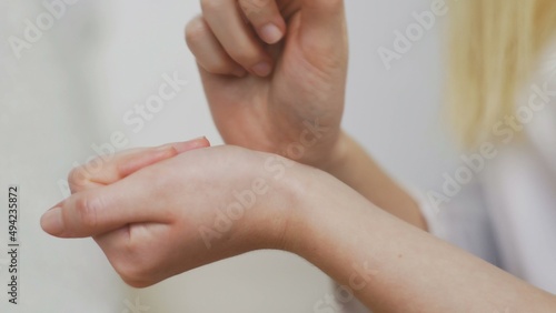 Close-up of an unrecognizable girl applying perfume on her wrist