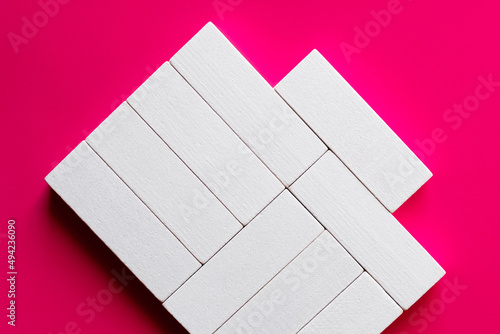 top view of white rectangular shape blocks on pink background. photo