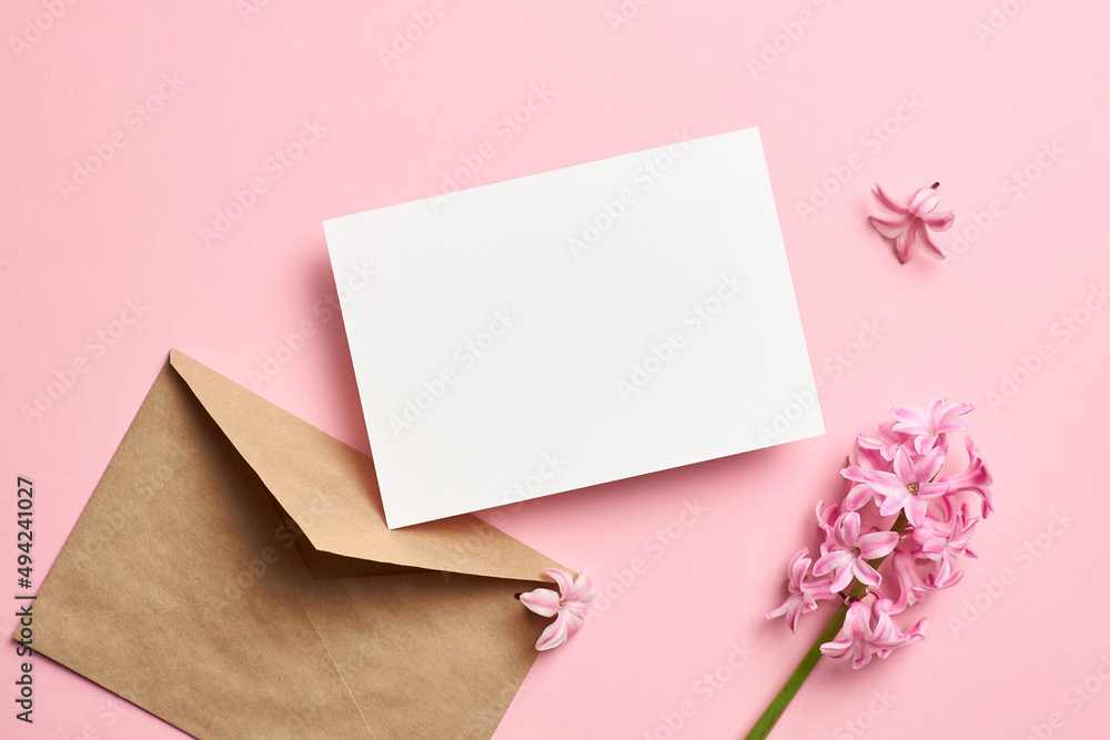 Invitation or greeting card mockup with envelope and hyacinth flowers on pink background Invitation or greeting card mockup with envelope and hyacinth flowers on pink background
