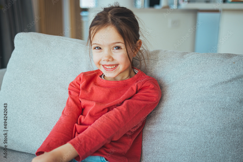 Stylish girl with pretty face at home. Little girl with long hair. Beauty and kid fashion with healthy hair. Portrait of a happy laughing child girl Stylish girl with pretty face at home. Little girl with long hair. Beauty and kid fashion with healthy hair. Portrait of a happy laughing child girl