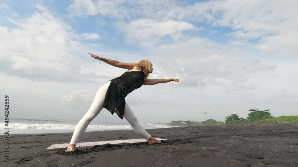 Woman doing yoga on the beach. 