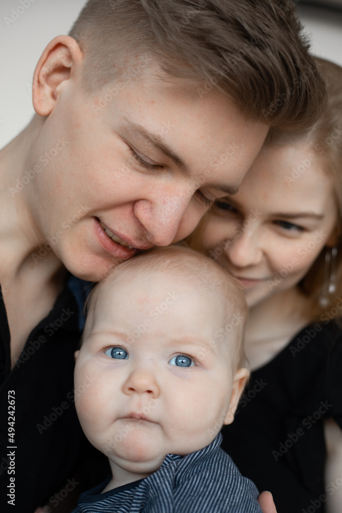 Vertical photo smiling calm family, woman, man and baby, kissing and spending time together. Father daughter. Close up Vertical photo smiling calm family, woman, man and baby, kissing and spending time together. Father daughter. Close up