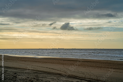 Coast of North sea with dark clouds and passing ships 