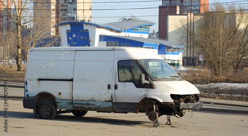 Old rusty white minibus without front wheels, Podvoysky Street, Saint Petersburg, Russia, March 2022
