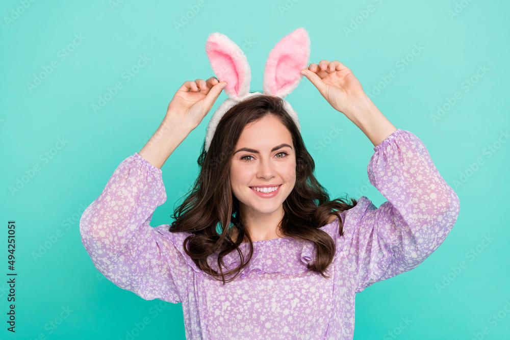 Portrait of satisfied adorable girl hands touch bunny ears accessory headband isolated on turquoise color background Portrait of satisfied adorable girl hands touch bunny ears accessory headband isolated on turquoise color background