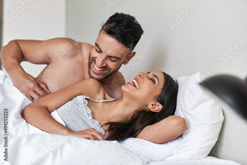 Tickling helps her wake up. Cropped shot of an affectionate young married couple in bed at home. © Nikish H/peopleimages.com