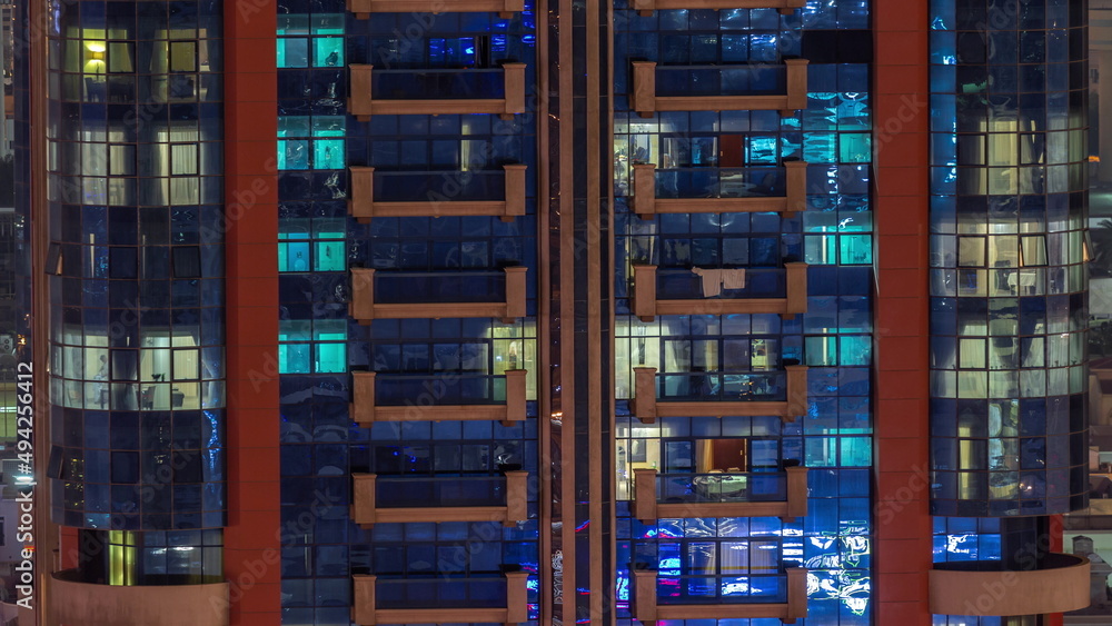 Night aerial view of apartment building glass window facade with illuminated lighted workspace rooms timelapse. Night aerial view of apartment building glass window facade with illuminated lighted workspace rooms timelapse.