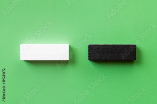 top view of two white and black blocks on green background. photo