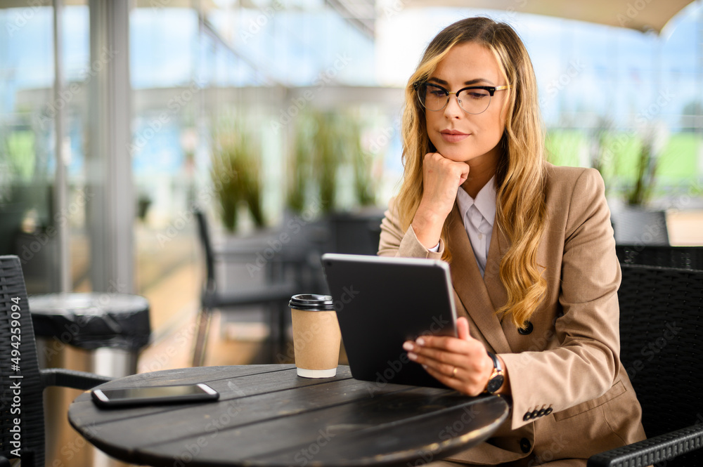 Young businesswoman on a coffee break. Using tablet computer. Young businesswoman on a coffee break. Using tablet computer.