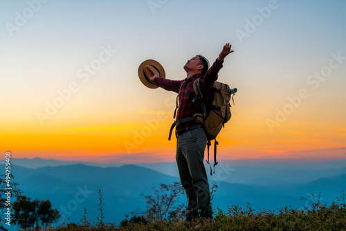 Men hike for tusks, happy to travel on the top of the mountain, sunset with a large backpack, lifestyle travel, adventure travel in the summer, outdoor travel alone in the forest.