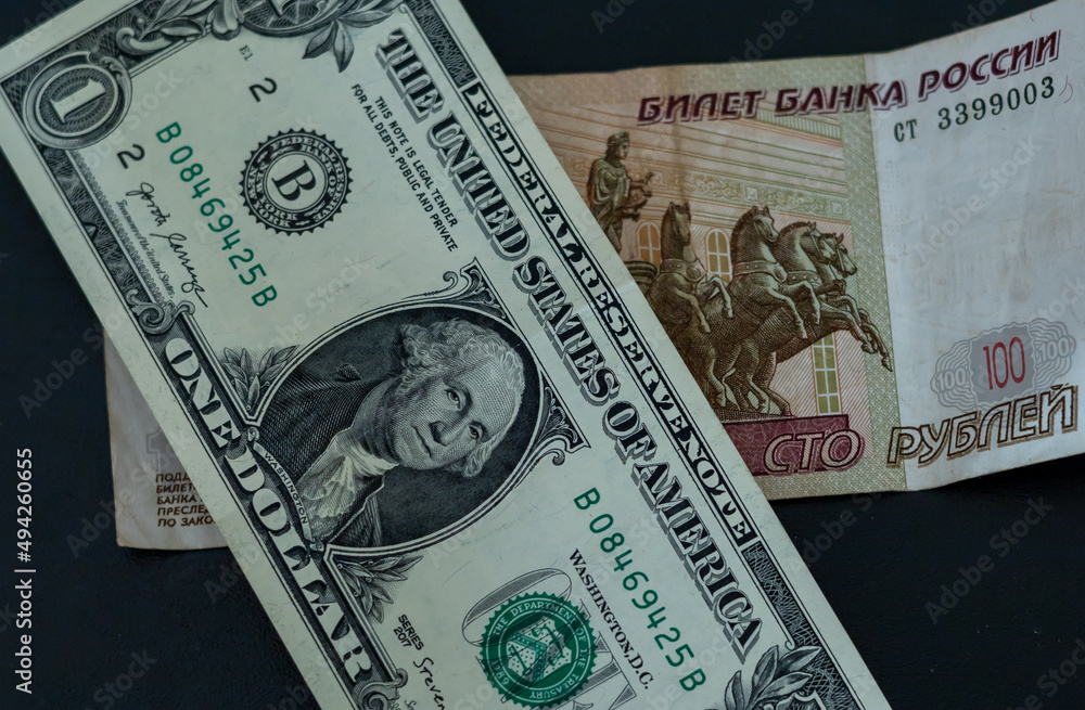 1 american dollar and 100 russian rubles banknote on the table. 1 american dollar and 100 russian rubles banknote on the table.