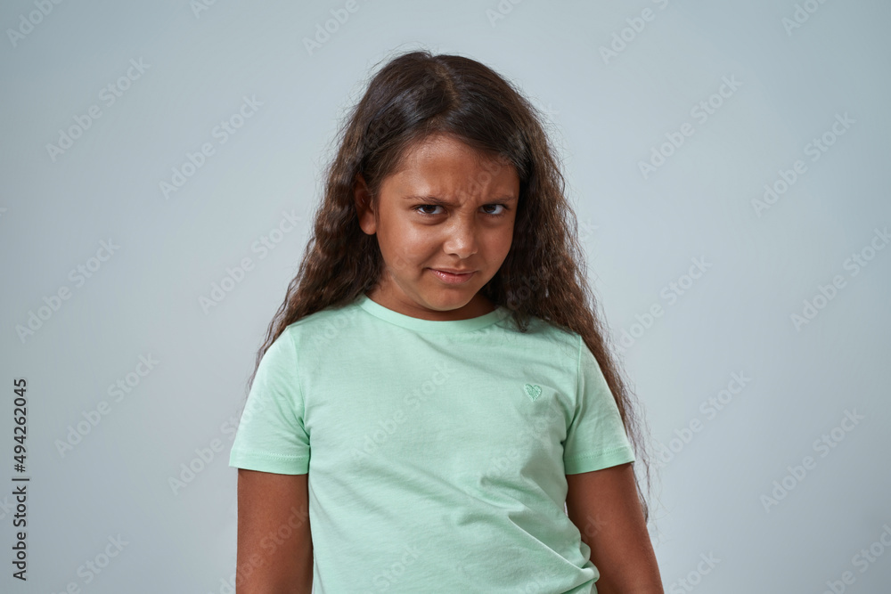 Dissatisfied hispanic little girl look at camera Dissatisfied hispanic little girl look at camera