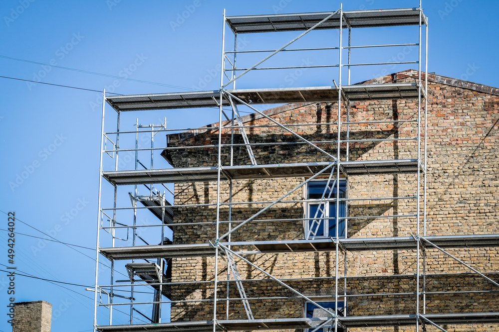 Reconstruction of an old brick house. Scaffolding for construction, construction site. Selective focus Reconstruction of an old brick house. Scaffolding for construction, construction site. Selective focus