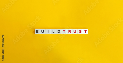 Build Trust Phrase on Letter Tiles on Yellow Background. Minimal Aesthetics.