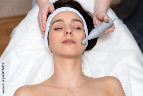 A girl's face in close-up during a facial treatment at a cosmetologist.The cosmetologist does biomechanical stimulation of the face to the client.The concept of professional cosmetology.
