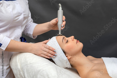 Fotografie A girl's face in close-up during a facial treatment at a cosmetologist