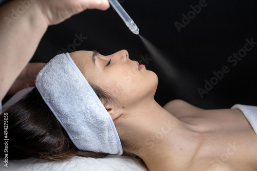 A cosmetologist does a gas-liquid peeling procedure for a young girl.A girl in the cosmetologist's office during the procedure.Face and neck care in a beauty salon.Cosmetic procedures for the face