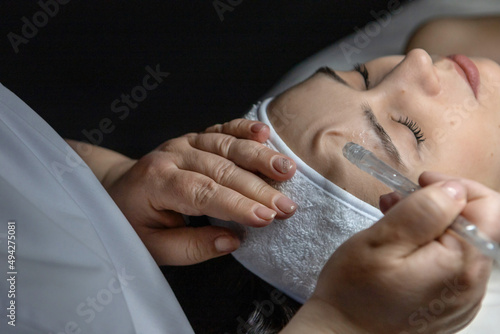 A cosmetologist does a gas-liquid peeling procedure for a young girl.A girl in the cosmetologist's office during the procedure.Face and neck care in a beauty salon.Cosmetic procedures for the face
