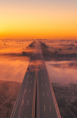 Fototapete Orange Sonnenuntergang über leerer Autobahn  © Malik