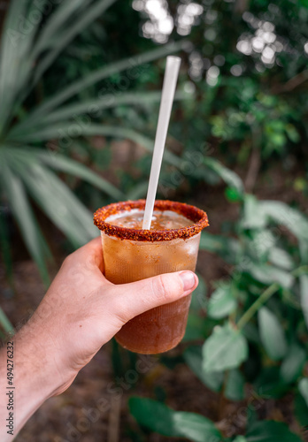 Crop man with glass of michelada drink photo