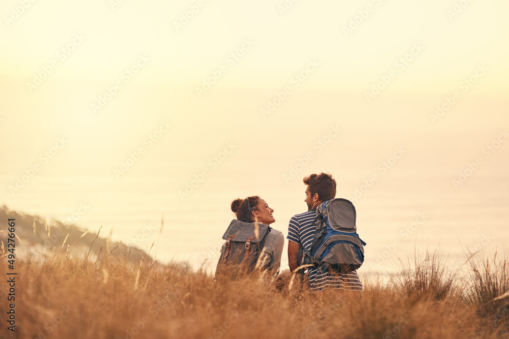 He knows just how to steal my heart. Rearview shot of a couple taking a break after hiking. He knows just how to steal my heart. Rearview shot of a couple taking a break after hiking.