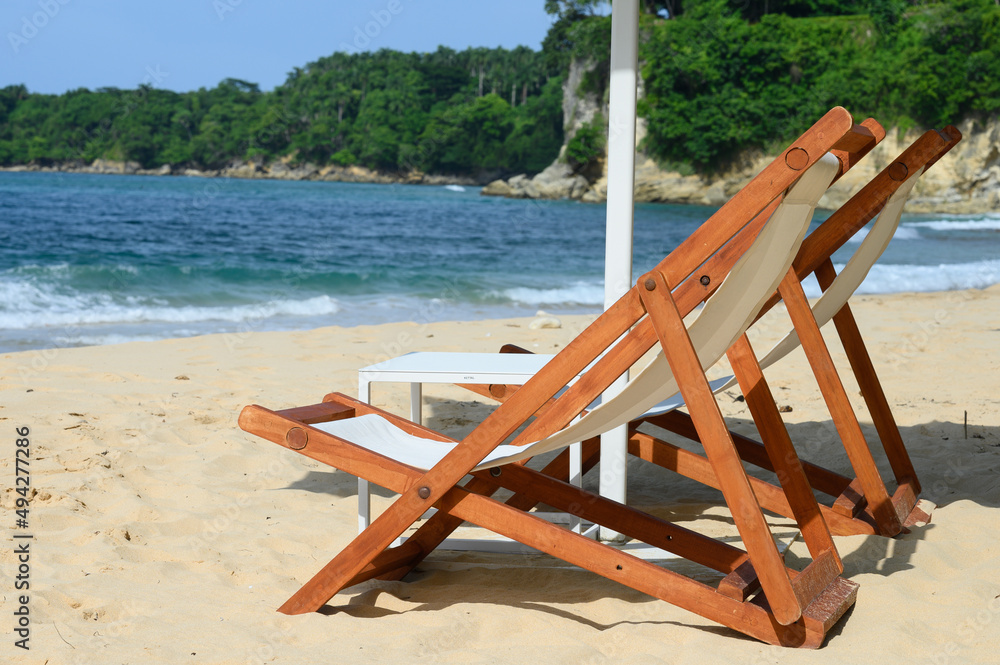 Wooden sun loungers on white sandy beach-4