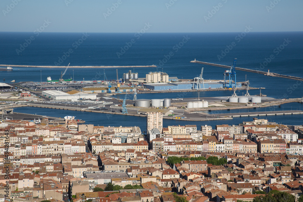 Panoramic view from the top of the mountain Mont St. Clair over Sète’s terracotta roofs to the city, port and mediterranean Sea. The town is interlaced by its network of canals and bridges. 