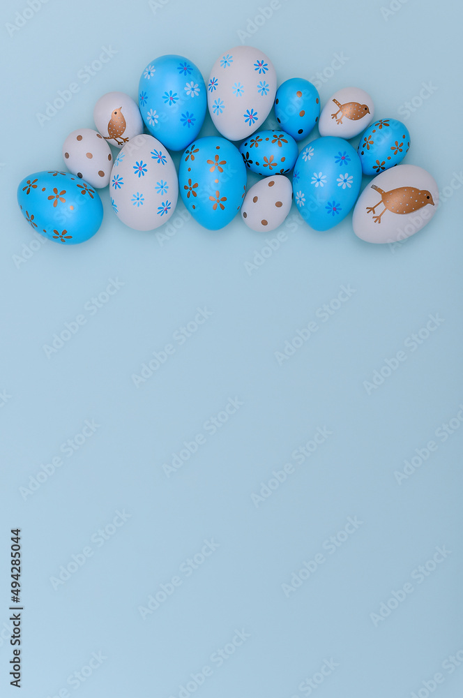 White and blue Easter eggs on blue background. Happy Easter card with copy space. Easter composition of decorated eggs. White and blue Easter eggs on blue background. Happy Easter card with copy space. Easter composition of decorated eggs.