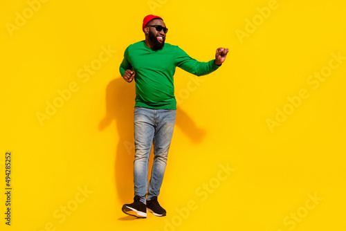 Fototapeta Naklejka Na Ścianę i Meble -  Photo of crazy cheerful dancer man have weekend fun wear sunglass red beanie green shirt isolated yellow color background
