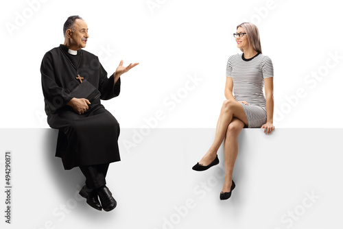 Priest and a young woman sitting on a panel and having a conversation