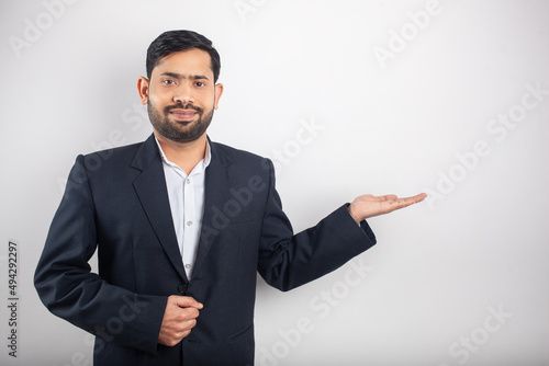 smiling indian businessman showing empty hand palm for imaginary product for visual ads or advertisement