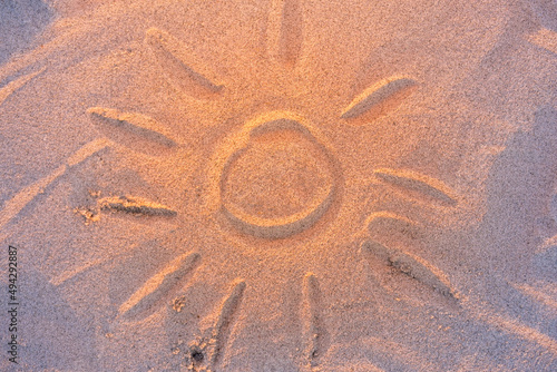 close-up of the sun painted on the sand on a summer day