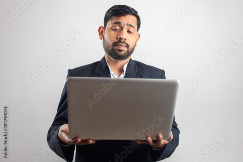 Photography suit man feeling tired while using laptop in white background