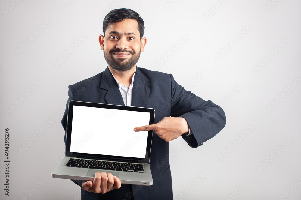 happy smiling businessman showing empty laptop screen and pointing finger to screen happy smiling businessman showing empty laptop screen and pointing finger to screen
