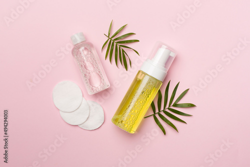Quadro su tela Foaming facial cleanser and micellar water on color background, top view