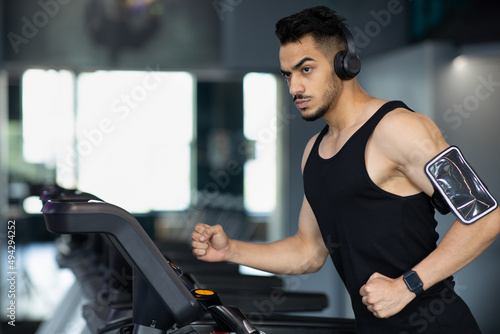 Portrait Of Confident Muscular Arab Man Training On Treadmill At Modern Gym