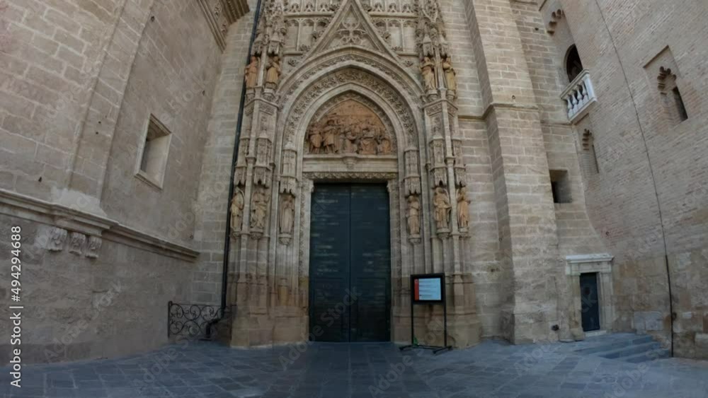 Seville, Spain, September 11, 2021: TILT SLOW - Detail of Main door of the Assumption of Saint Mary of the See cathedral, in the center of the west facade, is well-preserved and elaborately decorated. Seville, Spain, September 11, 2021: TILT SLOW - Detail of Main door of the Assumption of Saint Mary of the See cathedral, in the center of the west facade, is well-preserved and elaborately decorated.
